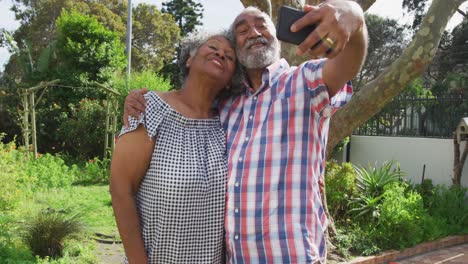 Animation-of-african-american-senior-couple-taking-selfie-in-garden