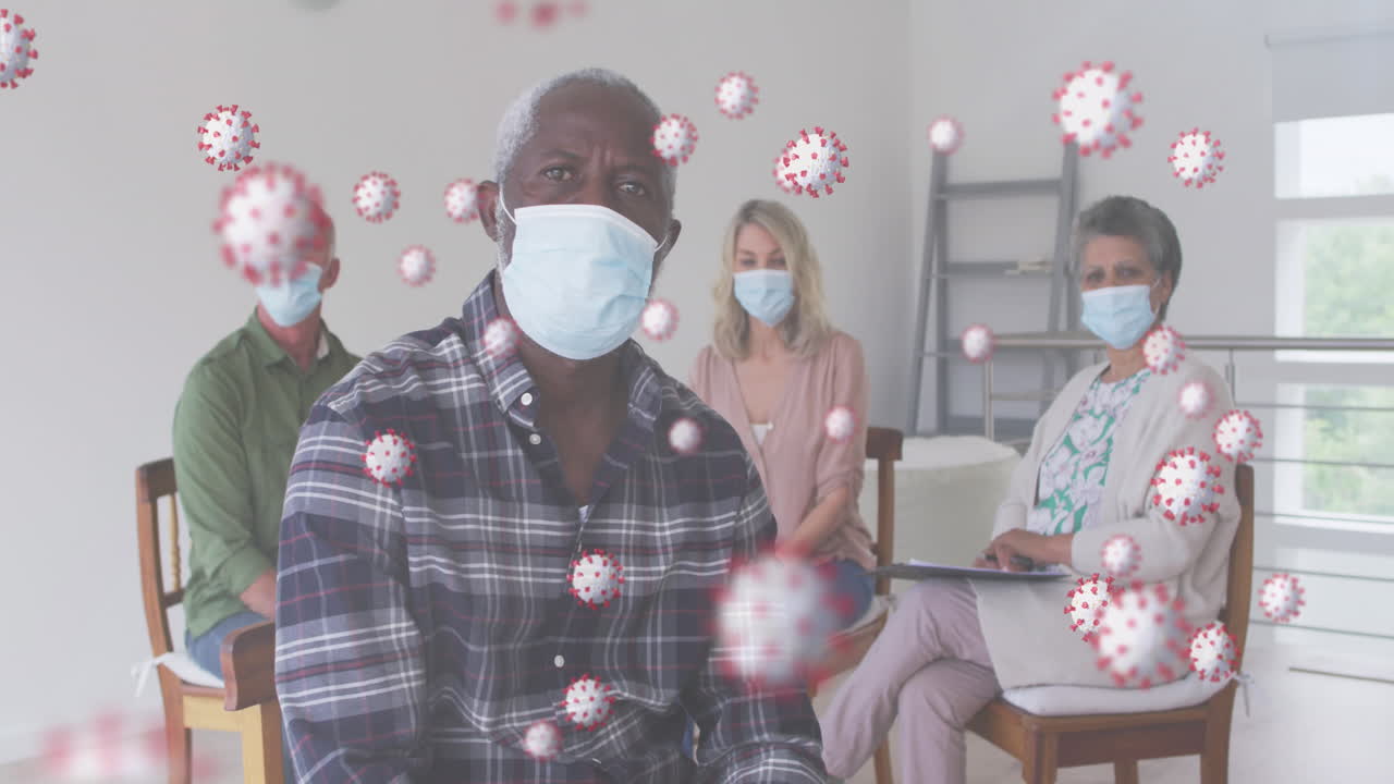 집에 앉아 있는 얼굴 마스크를 쓰고 있는 사람들의 집단에 대해 떠다니는 여러 개의 코로나19 세포