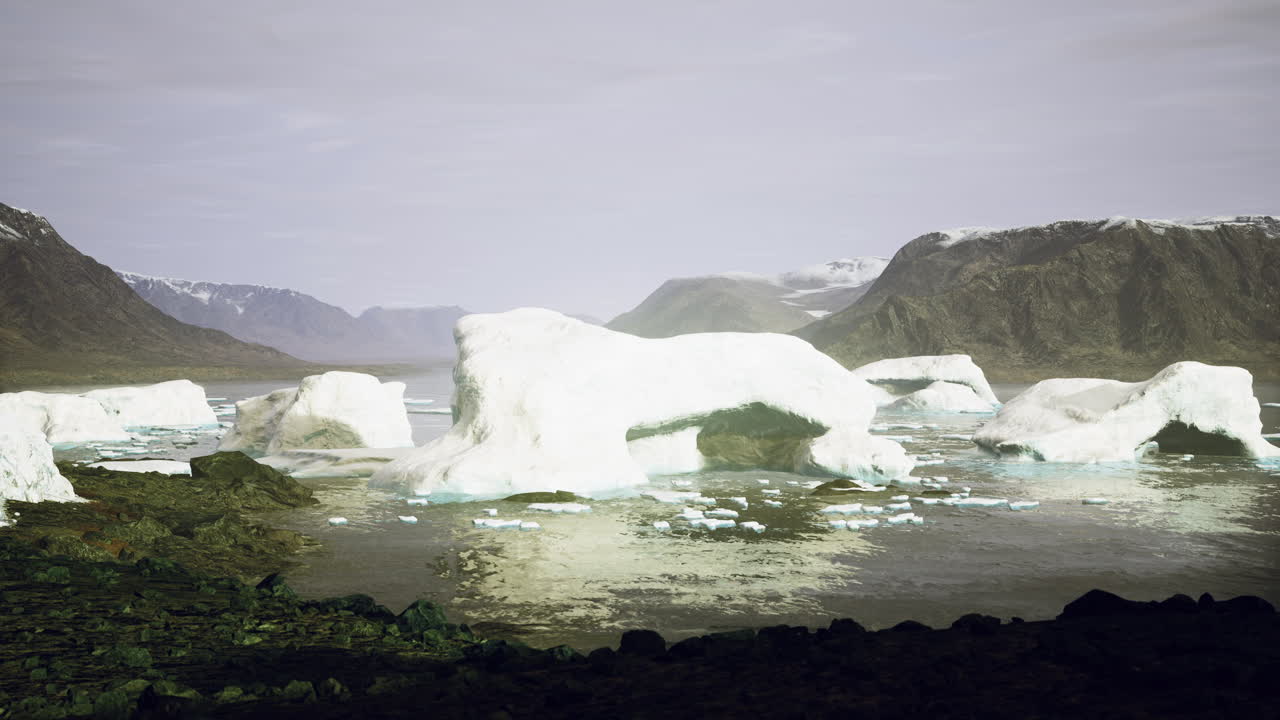 Icebergs drift serenely in calm waters amidst rugged mountain landscape