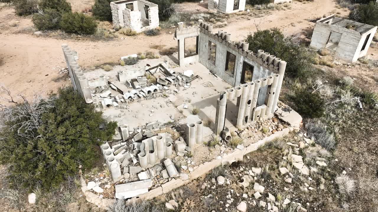 edificio abandonado estructura de hormigón destruido por el cártel en el alto desierto del sur de california en un día nublado con un estado de ánimo apocalíptico órbita aérea 60fps