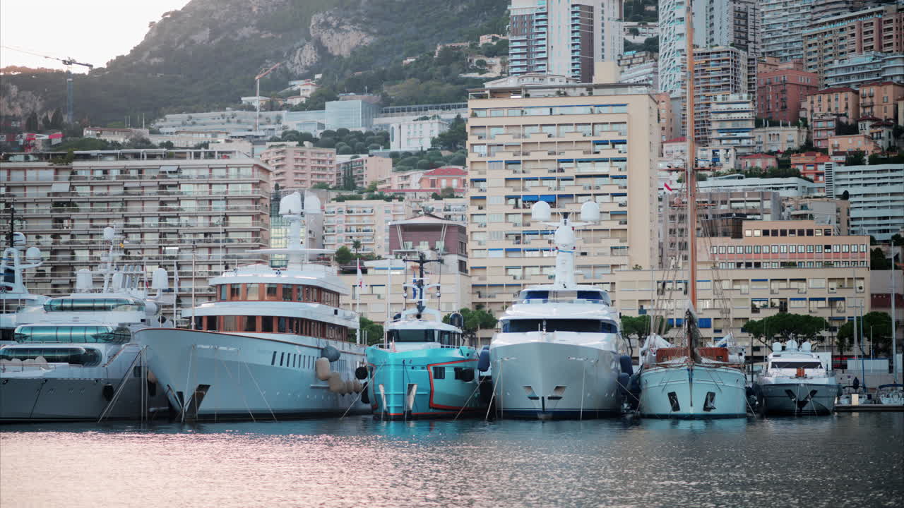 View of boats docked in the Monaco Marina with the skyline of the city on the background