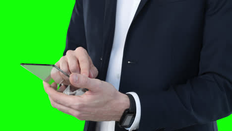 mid section of a caucasian man holding a transparent screen on green background