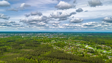 panorama of rural neighborhood in lush forest under rolling clouds. time lapse