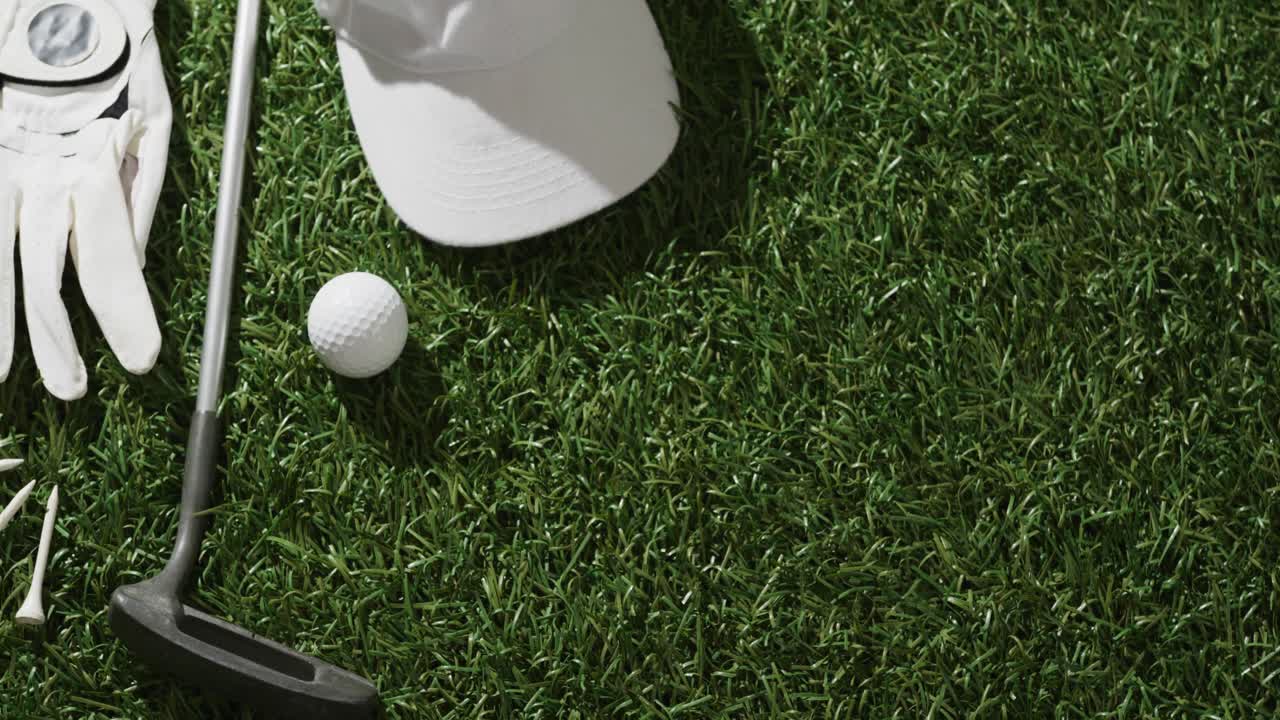 Primo piano di mazza da golf, pallina, guanto e berretto con visiera sull'erba, spazio per il testo, rallentatore