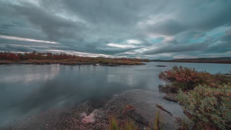 Una-Serena-Puesta-De-Sol-Sobre-Un-Río-Lento-Con-Nubes-Reflejándose-En-La-Superficie-Del-Agua-Cristalina