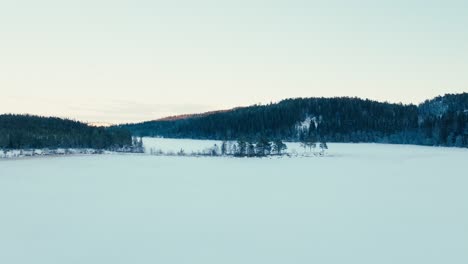 Indre-Fosen,-Condado-De-Trondelag,-Noruega---Las-Extensiones-Rurales-Cubiertas-De-Nieve-Y-Las-Montañas-Envueltas-Por-Bosques-Siempre-Verdes---Drones-Volando-Hacia-Adelante