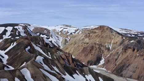 Descending-aerial-drone-view-focusing-on-the-Brandsgil-valley-in-Landmannalaugar,-Iceland