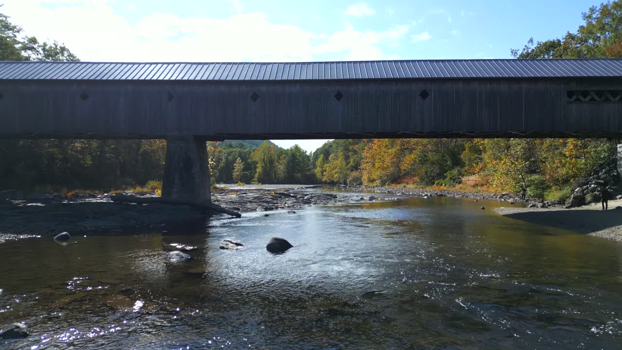 Low aerial fly through below West River Covered Bridge, West Dummerston Vermont