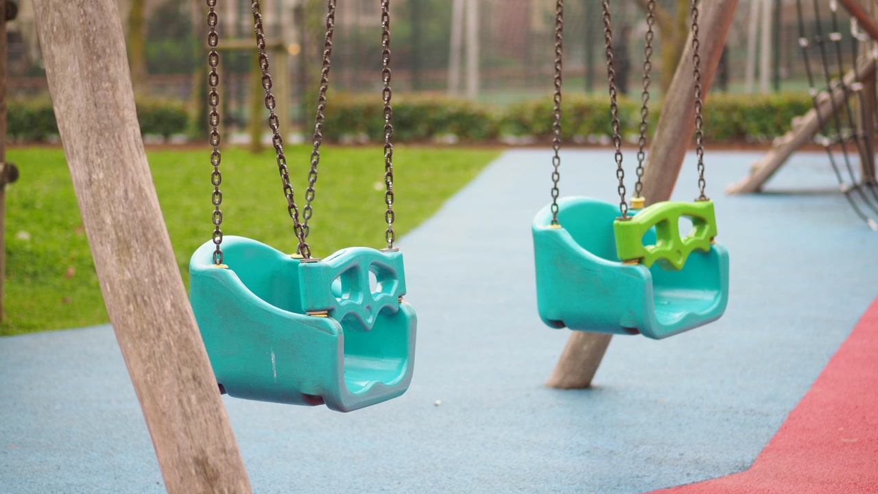 Empty Swings Gently Swaying in a Colorful Children's Playground