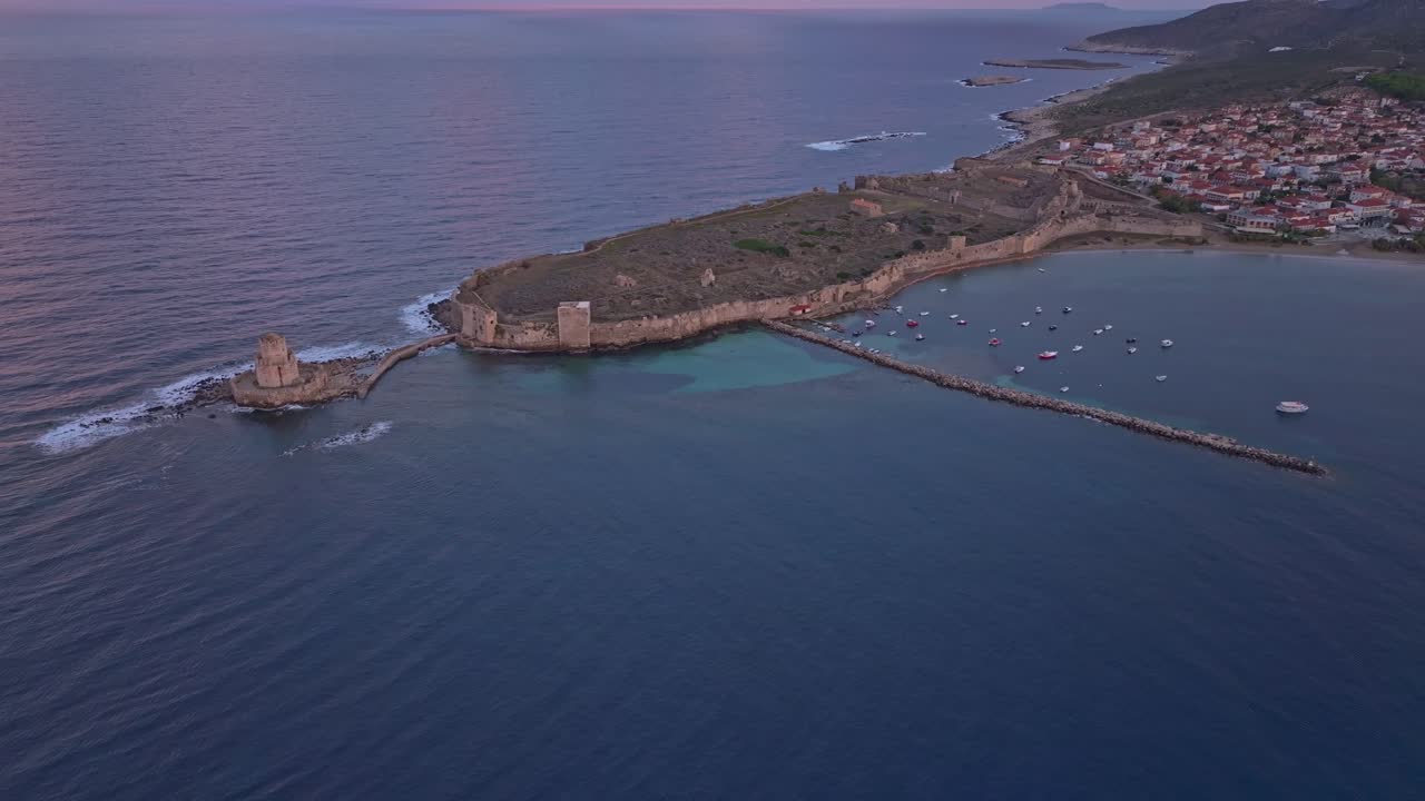 Luftfoto af solopgang, der spejler sig i historiske Methoni-mure ved havet