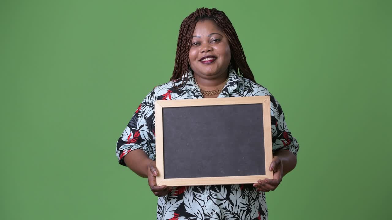 Overweight beautiful African woman against green background