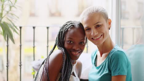 two happy diverse women sharing a moment on a balcony