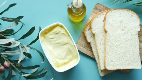 Fresh-butter-in-a-container-with-bread-on-white-background