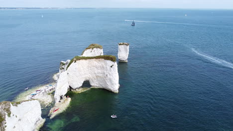 unrecognizable tourists exploring rock formations of old harry rocks, uk