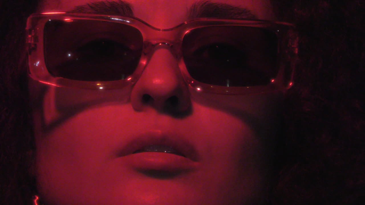 Portrait of Stylish Woman in Red Neon Light under Dark Concrete Overpass