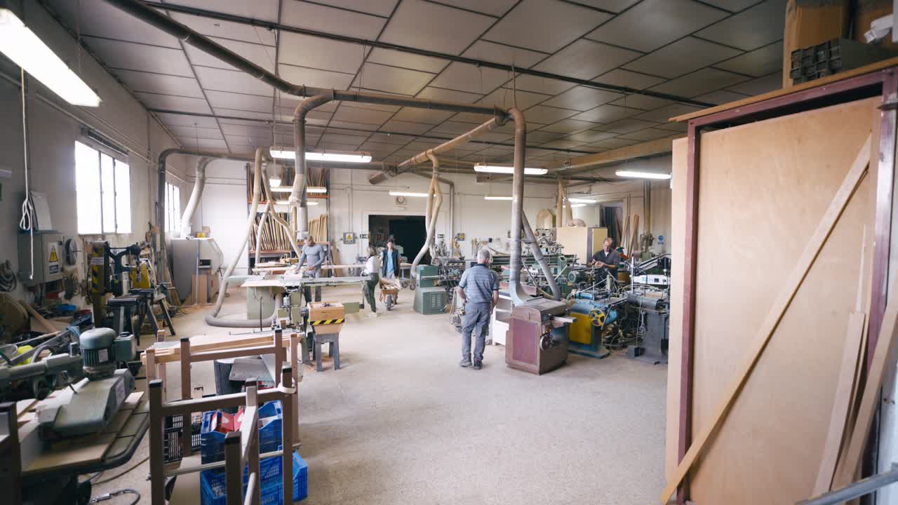 Busy Woodworking Workshop with Carpenters Operating Machinery