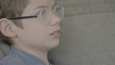 closeup profile of young boy playing video games on the couch