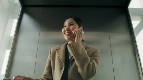 businesswoman talking on phone in elevator