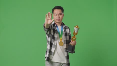 hombre con trofeo y gesto de parada