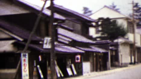 1951: japanese quiet street woman riding bike in distance.