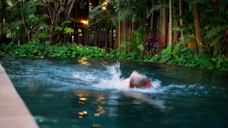 tropical resort pool with swimmer, lush plants near ancient angkor thom cambodia