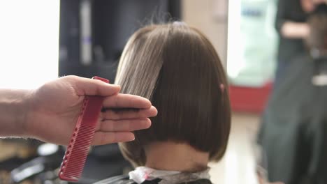 detailansicht der hände eines friseurs, der haare mit einer schere schneidet 1