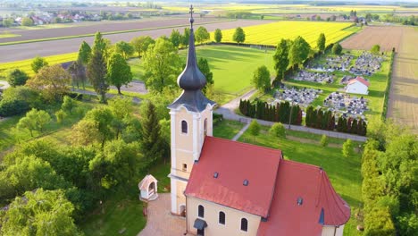 Aerial-hovering-over-orthodox-church-in-Hungarian-village,-central-Europe