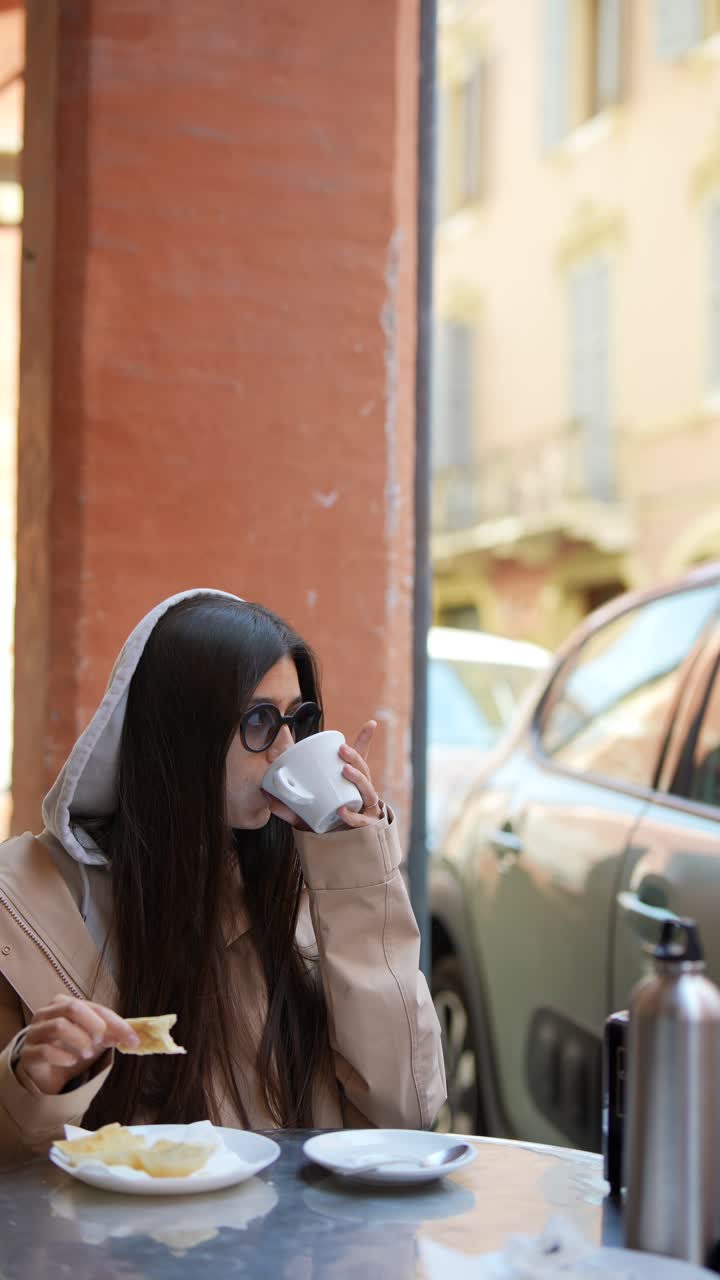 Woman enjoying coffee and snacks in a European city cafe