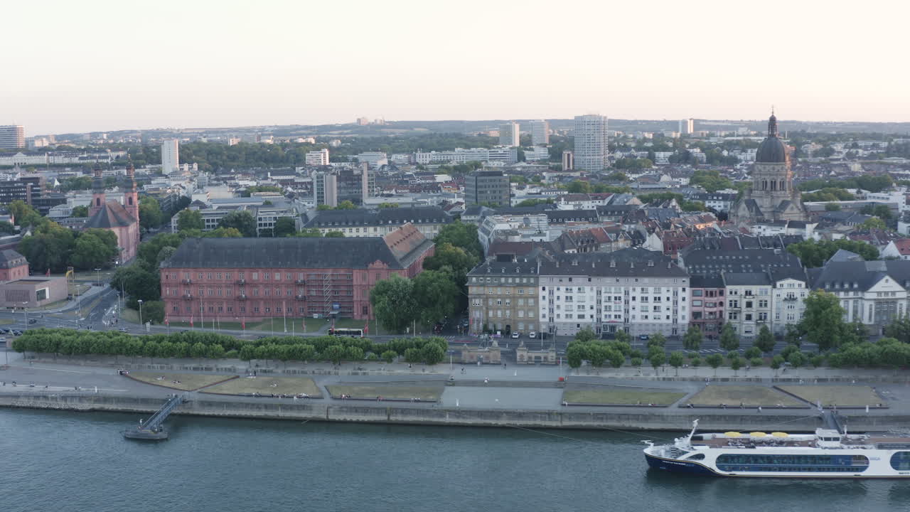 Vista aerea circolare con drone della Christuskirche di Magonza, del castello, del fiume Reno e del panorama urbano al tramonto, Germania 4k.