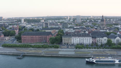 aerial circling drone view of mainz christuskirche, castle, river rhine and cityscape at sunset germany 4k