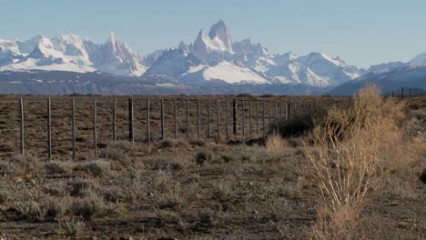 pan across a fenced region in the far southern region of patagonia with the fitzroy range in background