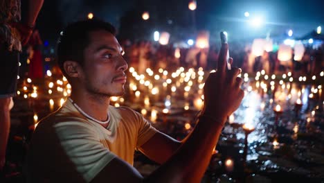 person taking photo at a night festival with candles and lanterns