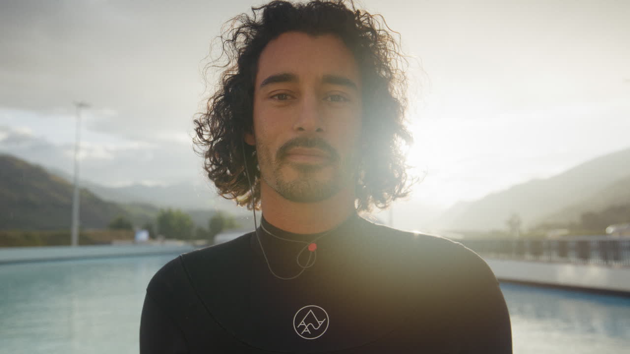 Surf ad alte prestazioni in una moderna piscina a onde in una giornata serena con acqua cristallina. Curve potenti, tubi e spruzzi incorniciati dalle Alpi svizzere creano un ambiente unico per il surf alpino.