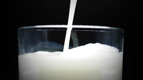 macro of fresh milk poured in crystal clear glass