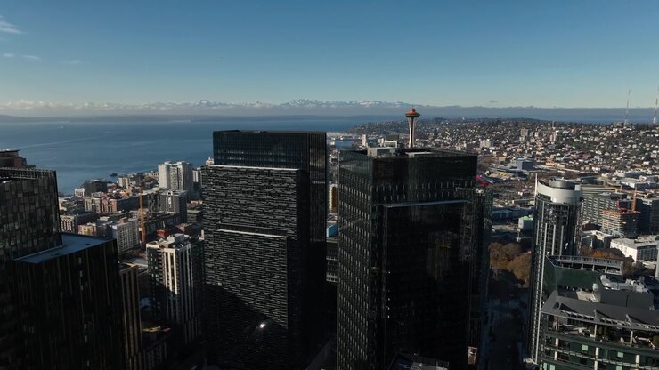 Vista aérea de arranha-céus com a Space Needle e montanhas no horizonte, Seattle