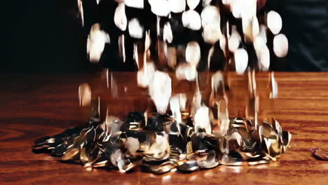 coins falling on wooden table