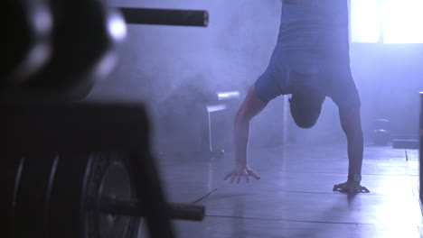 man doing a handstand in the gym