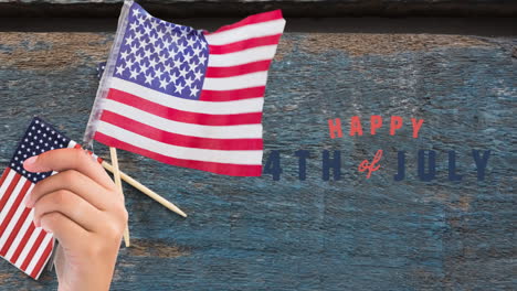 animation of 4th of july text over person holding american flags