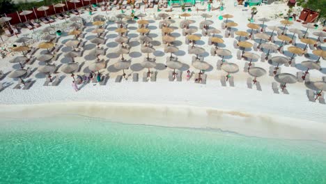 Drone-View-With-Side-Movement-Revealing-The-Beautiful-Marble-Beach,-With-Crystal-Clear-Water,-White-Pebbles,-Lush-Green-Vegetation,-Umbrellas-And-Sunbeds,-Thassos-Island,-Greece,-Mediterranean-Sea