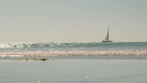 Glitzerndes-Meer-Mit-Entferntem-Segelboot-In-Palavas,-Frankreich