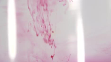 red paint dissolving in water shot in slow motion with sony a7iii.