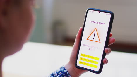 Nahaufnahme-Einer-Frau-Mit-Mobiltelefon-Und-Covid-19-Track-and-Trace-Alarm-Auf-Dem-Bildschirm-–-Aufgenommen-In-Zeitlupe