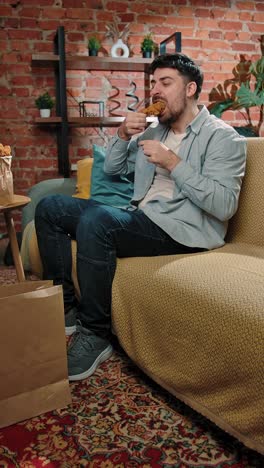 man eating fried chicken on the couch