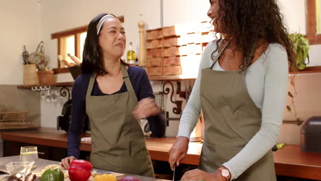 multiracial female friends preparing vegetables together in kitchen, enjoying cooking at home