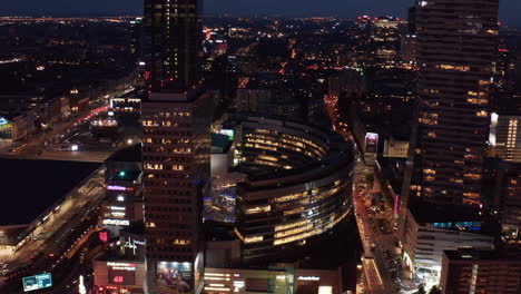 Aerial-night-footage-of-downtown.-Revealing-Zlote-Tarasy-modern-shopping-and-entertainment-complex.-Warsaw,-Poland