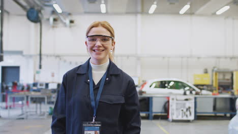 portrait of female student wearing safety glasses studying for auto mechanic apprenticeship