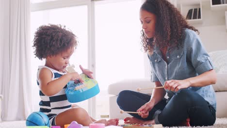 joven negra y su hija tocando instrumentos