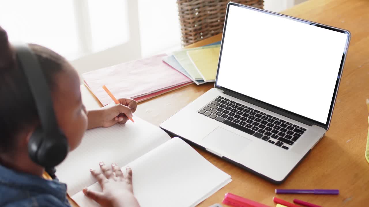 escolar afroamericana teniendo clase en la llamada de video portátil con espacio de copia en cámara lenta