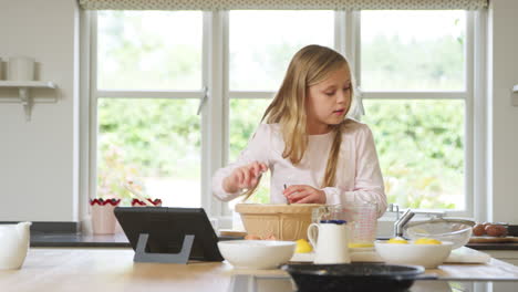 Chica-En-Pijama-Horneando-En-La-Cocina-De-Casa-Siguiendo-La-Receta-En-Una-Tableta-Digital