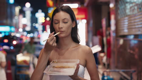 woman eating street food at night